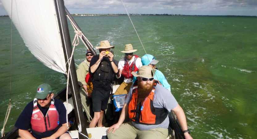 A group of veterans navigate a sailboat on an outward bound sailing trip.